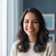 Portrait of a smiling woman looking at the camera, conveying happiness and trust.